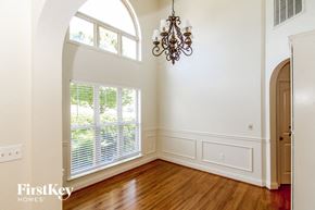 Chelsea house for rent - A chandelier hangs over a window in a white room.