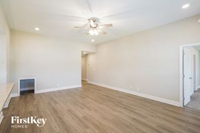 Clarksville house for rent - a living room with white walls and wood flooring and a ceiling fan