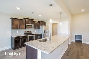 Clarksville house for rent - a kitchen with black cabinets and a granite counter top