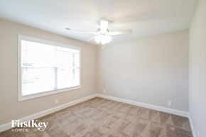 Clarksville house for rent - a bedroom with a large window and a ceiling fan