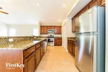 Lehigh Acres house for rent - a kitchen with stainless steel appliances and granite counter tops