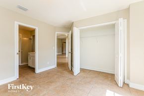 Lehigh Acres house for rent - a bedroom with two closets and a hallway to a bathroom and a closet