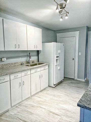 Forth Worth apartment for rent - a white kitchen with white cabinets and a white refrigerator