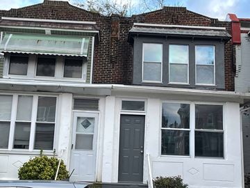 Philadelphia apartment for rent - A two-story house with a grey front door and white trim.