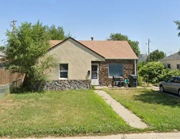 Scottsbluff house for rent - a brick house with a tree and a sidewalk