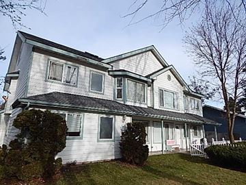 Post Falls apartment for rent - a white house with a porch and a yard