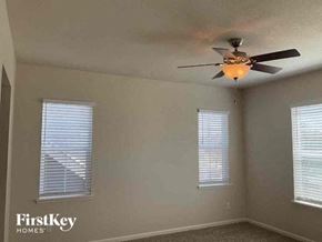 Aurora house for rent - a bedroom with a ceiling fan and two windows