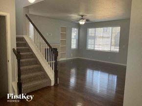 Aurora house for rent - a living room with a staircase and a ceiling fan