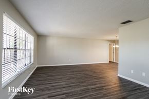 Cape Coral house for rent - an empty living room with wood flooring and a large window