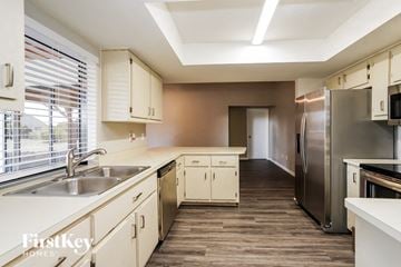 Cape Coral house for rent - a kitchen with white cabinets and stainless steel appliances