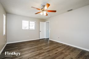 Cape Coral house for rent - a living room with white walls and a ceiling fan