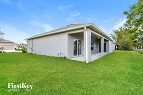 Kissimmee house for rent - a white house with a lawn and a grassy yard