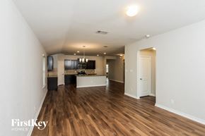 San Antonio house for rent - A spacious room with wooden floors and a white door.