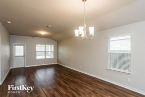 San Antonio house for rent - A room with wooden floors and a chandelier hanging from the ceiling.
