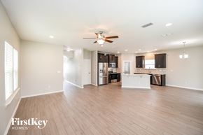 Jacksonville house for rent - A spacious living room with a kitchen in the background and a wood floor.