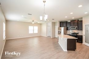 Jacksonville house for rent - A spacious kitchen and living room with wood flooring and a ceiling fan.