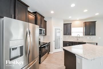 Jacksonville house for rent - A kitchen with a stainless steel refrigerator and wooden cabinets.