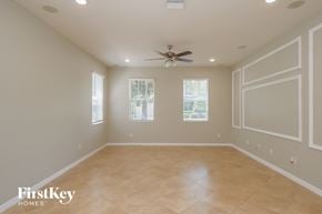 Riverview house for rent - A spacious room with a ceiling fan and two windows.