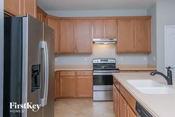 Riverview house for rent - A kitchen with wooden cabinets and a stainless steel refrigerator.