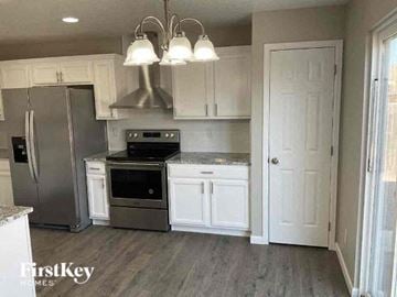 Lochbuie house for rent - a kitchen with stainless steel appliances and white cabinets