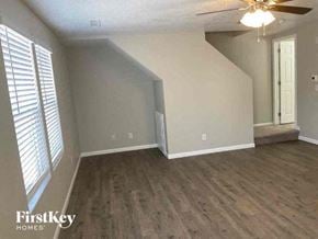 Lochbuie house for rent - an empty living room with wood floors and a ceiling fan