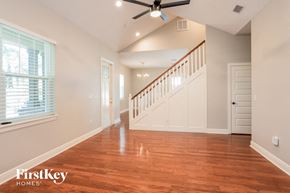 Plant City house for rent - a living room with a staircase and a large window and a wood floor