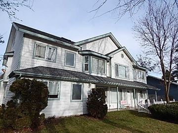 Post Falls apartment for rent - A two-story house with a white exterior and a grey roof.