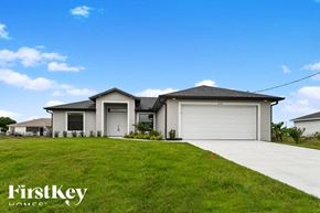 Lehigh Acres house for rent - a house with a garage door and a lawn