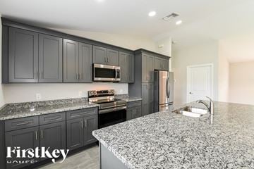 Lehigh Acres house for rent - a kitchen with granite counter tops and black cabinets