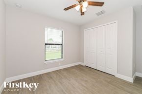 Lehigh Acres house for rent - an empty bedroom with a ceiling fan and a window