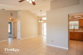 North Port house for rent - an empty kitchen and living room with a ceiling fan