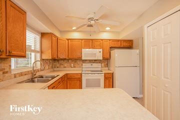 North Port house for rent - a kitchen with white appliances and wooden cabinets