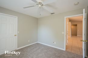 North Port house for rent - a bedroom with a ceiling fan and a door to a hallway