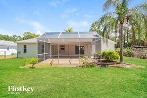 North Port house for rent - a house with a screened in porch and a grass yard