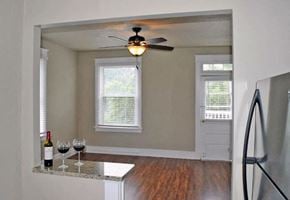 Norfolk apartment for rent - an empty living room with a ceiling fan and a table with wine glasses