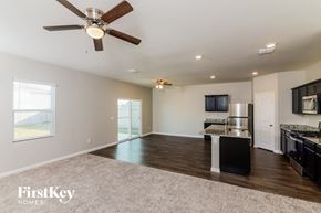 Saint Hedwig house for rent - an empty living room with a kitchen and a ceiling fan