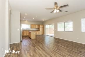 Laveen house for rent - an empty living room and kitchen with a ceiling fan