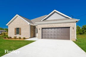 Parrish house for rent - A house with a garage door and a driveway in front of it.