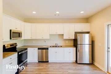 Parrish house for rent - A kitchen with white cabinets and a stainless steel refrigerator.