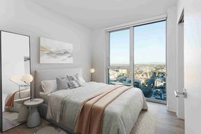 Long Beach apartment for rent - A bedroom with a large bed and a view of the city.