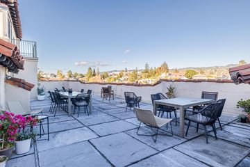 Oakland apartment for rent - A patio with a table and chairs overlooking a cityscape.