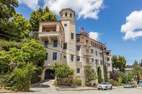Oakland apartment for rent - A large beige building with a tower and a flag on top.