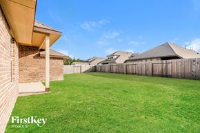 Conroe house for rent - A backyard with a wooden fence and a grassy area.