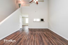 Houston house for rent - A room with wooden floors and a staircase leading to another room.