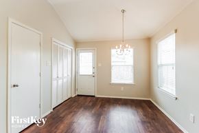 Humble house for rent - an empty living room with wood flooring and a chandelier