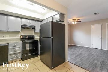 Spring house for rent - a kitchen with stainless steel appliances and a black refrigerator