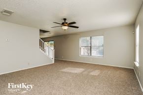 San Antonio house for rent - A spacious room with a fan and carpeted floor.