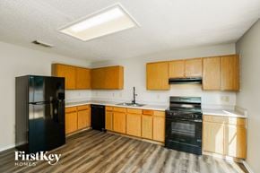 San Antonio house for rent - A kitchen with wooden cabinets and a black fridge.