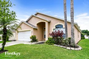 Davenport house for rent - a beige house with palm trees and a lawn