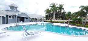 Sarasota house for rent - A large swimming pool with a small building next to it.